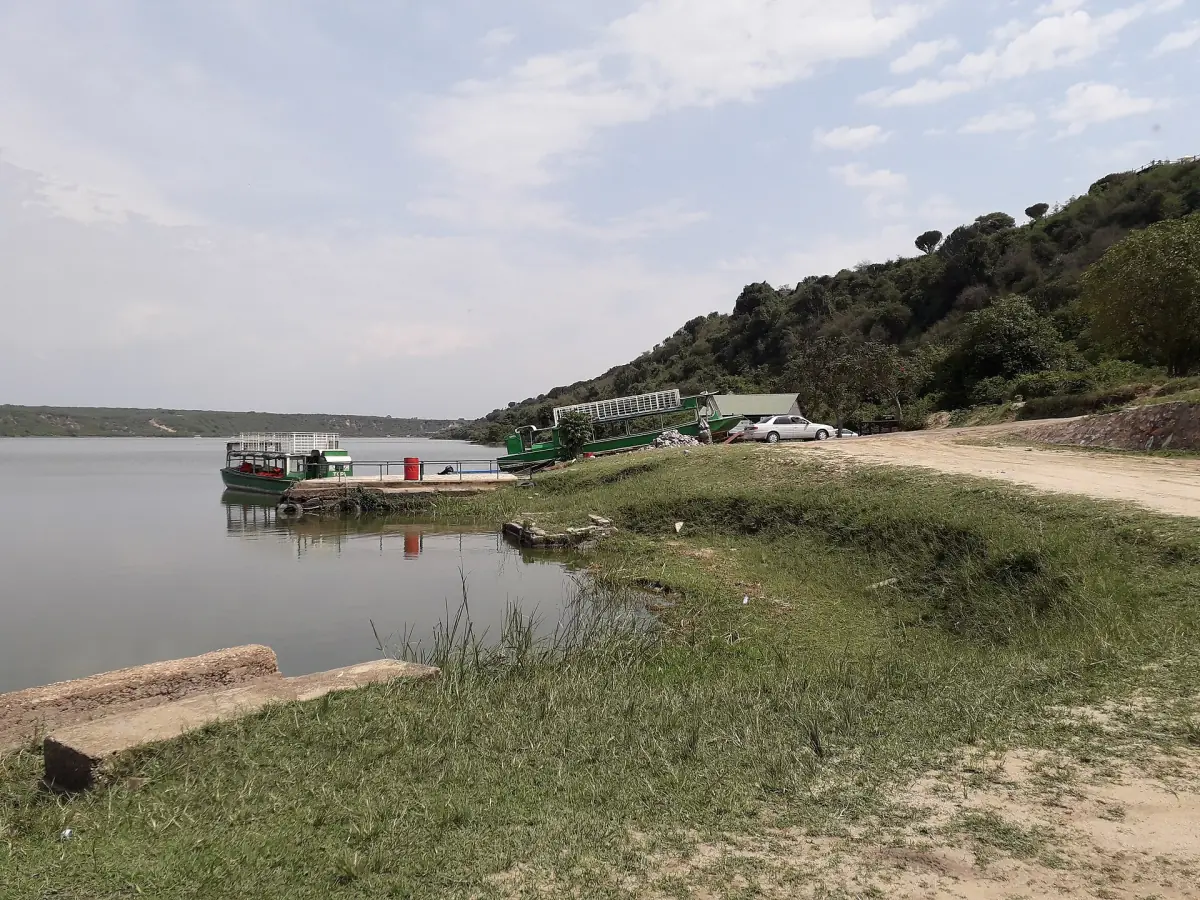 A boat landing on the shore of the channel with a wooded slope behind