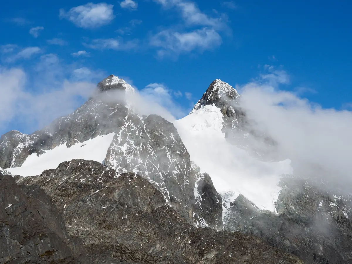 Snow-covered rocky peaks of the Rwenzori Mountains among clouds