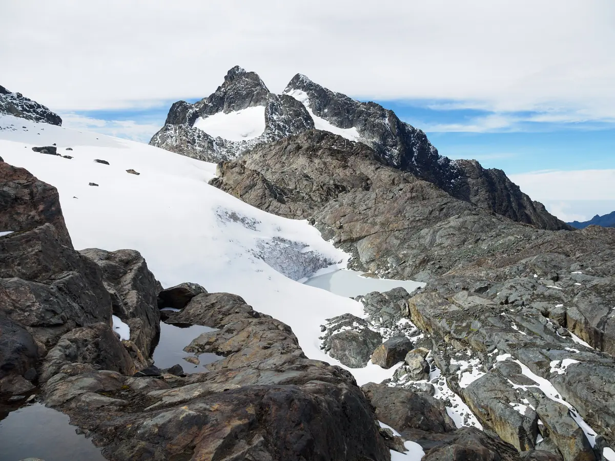 A glacier on dark rock on the Stanley Plateau in the Rwenzori Mountains
