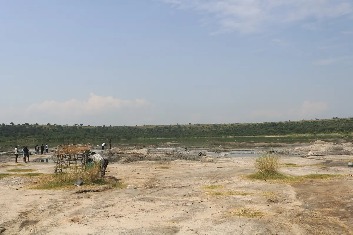 A pale salt flat and shallow salt lake under a hazy sky