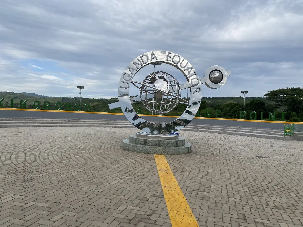 The metal equator monument on a paved plaza at Kikorongo